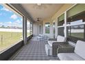 Comfortable screened-in lanai featuring cushioned wicker furniture and modern patterned rug at 12848 Hilary St, Spring Hill, FL 34609