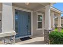Charming front entrance with decorative stone accents and a stylish blue front door at 13619 Hunters Point St, Spring Hill, FL 34609