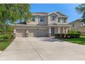 Inviting two-story home featuring a three-car garage, manicured lawn and charming curb appeal at 13619 Hunters Point St, Spring Hill, FL 34609