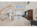 Elegant living room featuring a large staircase, soaring ceilings, and french doors with water views at 1473 Sail Harbor Cir, Tarpon Springs, FL 34689