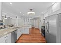 Spacious kitchen with stainless steel appliances, granite counters, and wood-look flooring at 155 Patty Ann Blvd, Palm Harbor, FL 34683
