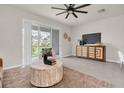 Cozy living room featuring a comfortable chair, view to the backyard and a stylish entertainment center at 16177 Glowing Grove Ave, Odessa, FL 33556