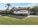 Beige single-story home featuring a well-maintained lawn, trimmed hedges, and a side entry garage at 1641 Bayfield Ct, Trinity, FL 34655