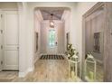 Elegant foyer featuring decorative tile ceiling, wood-look floors, and a stylish front door at 1771 Whitewillow Dr, Wesley Chapel, FL 33543