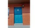 Vibrant blue front door with brick surround and stylish wall-mounted lantern at 24862 Us Highway 19 N # 203, Clearwater, FL 33763