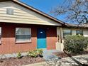 Charming brick exterior with a welcoming blue front door and well-maintained landscaping at 24862 Us Highway 19 N # 203, Clearwater, FL 33763