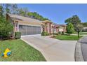 Lovely home with a screened garage, brick accents, an American flag, and a well-maintained front lawn at 3013 Appleblossom Trl, Spring Hill, FL 34606