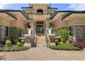 The home's inviting front entrance features stone pillars, an archway, and manicured landscaping at 3026 Wentworth Way, Tarpon Springs, FL 34688