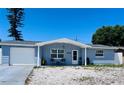 Charming single story home featuring a garage, blue paint and rock landscaping at 3309 Bayport Dr, Holiday, FL 34691