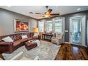 Comfortable living room with brown leather sofa, a ceiling fan, and hardwood flooring at 3515 Albritton St, New Port Richey, FL 34655