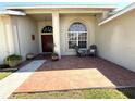 Inviting front porch with decorative tile, potted plants, chairs, and a view of the front door at 4748 Yellowstone Dr, New Port Richey, FL 34655