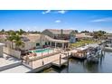 Waterfront property features a pool, hot tub, outdoor seating, boat dock, and lush tropical landscaping at 5033 Cabrilla Ct, New Port Richey, FL 34652