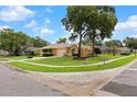 Lovely view of a home with a well-kept lawn, mature trees, and a quiet residential street at 5110 Championship Cup Ln, Spring Hill, FL 34609