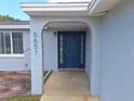 Inviting entryway with a blue front door and covered arch at 5651 Canosa Dr, Holiday, FL 34690