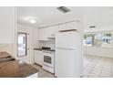 Functional kitchen featuring white appliances, ample cabinet space and convenient layout at 5706 Mockingbird Dr, New Port Richey, FL 34652