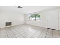 Bright living room showcasing tiled floors and a large window with decorative bars at 5706 Mockingbird Dr, New Port Richey, FL 34652