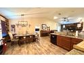 Open-concept dining area featuring modern lighting, wood accents, and a connected kitchen at 6054 Merrifield Dr, Zephyrhills, FL 33541