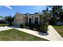 Charming single-story home featuring a two-car garage and nicely landscaped front yard at 6054 Merrifield Dr, Zephyrhills, FL 33541