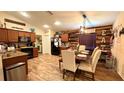 Open-concept dining area featuring modern lighting, wood accents, and a connected kitchen at 6054 Merrifield Dr, Zephyrhills, FL 33541