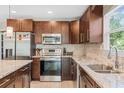 Modern kitchen featuring stainless steel appliances, granite countertops, and dark wood cabinets at 6104 Cork Ct, New Port Richey, FL 34653