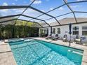 A stunning pool area with a hot tub, lounge chairs, and a dining area under a screened enclosure at 6229 Sea Air Dr, Apollo Beach, FL 33572