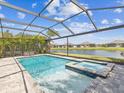 Sparkling screened-in pool and hot tub offer a private outdoor oasis, with a relaxing view of the lake at 6229 Sea Air Dr, Apollo Beach, FL 33572