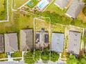 Aerial view of a residential property, surrounded by a fenced backyard and neighboring homes with solar panels at 635 Painted Leaf Dr, Brooksville, FL 34604