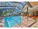 Beautiful screened-in pool with brick pavers, an attached spa and a spacious outdoor patio area at 7129 Myrtlewood Ln, Spring Hill, FL 34606