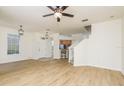 Open-concept living room with wood floors, ceiling fan and staircase access at 7500 Red Mill Cir, New Port Richey, FL 34653