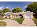 Charming one-story home with a brick facade, well-maintained lawn, and a curved driveway at 8505 Lincolnshire Dr, Hudson, FL 34667