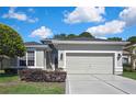Charming home featuring a well-manicured front yard, a concrete driveway, and a spacious two-car attached garage at 10109 Holly Berry Dr, Spring Hill, FL 34613