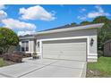 Beautiful single-story home featuring a manicured lawn, concrete driveway, and a spacious two-car attached garage at 10109 Holly Berry Dr, Spring Hill, FL 34613