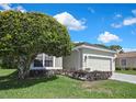 Attractive single-story home boasts a manicured lawn and an attached two-car garage and concrete driveway at 10109 Holly Berry Dr, Spring Hill, FL 34613