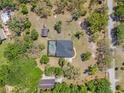 Aerial view of property featuring pool, backyard, and home in a private and lushly landscaped neighborhood at 10645 Fawn Dr, New Port Richey, FL 34654
