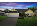 Charming home with a well-manicured lawn, two-car garage, and inviting curb appeal at sunset at 11630 Pasadena Rd, Dade City, FL 33525