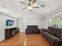 Cozy living room featuring hardwood floors, a ceiling fan, and comfortable leather seating at 11630 Pasadena Rd, Dade City, FL 33525