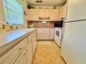 Cozy kitchen with white appliances, tile flooring, and ample cabinet space at 11814 Carissa Ln, New Port Richey, FL 34654