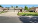 Beautiful single-story home with a three-car garage and lush green lawn at 11949 Wexford Blvd, Spring Hill, FL 34609