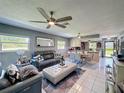 Open-concept living room with modern furnishings, tile floors, and abundant natural light at 12545 Dearborn Dr # D, Bayonet Point, FL 34667