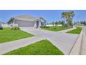 Well-maintained home featuring a spacious driveway, lush lawn, and mature landscaping at 13160 Golden Lime Ave, Spring Hill, FL 34609