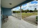 Covered front porch with white railings, a bench, and a view of the outdoors at 13377 Montour St, Brooksville, FL 34613