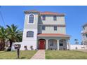 Stunning three-story waterfront home boasts lush landscaping, a red-tile roof, and a welcoming covered entry at 13741 Judy Ave, Hudson, FL 34667