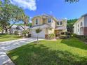 Beautiful yellow two-story home with a lush green lawn and mature trees in a serene setting at 16022 Westerham Dr, Tampa, FL 33647