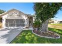 Beautiful house with a screened two-car garage, lovely landscaping, and a concrete driveway at 18109 Tiverton Ct, Hudson, FL 34667