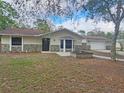 Charming single-story home featuring stone accents, neutral color palette, and mature trees at 18232 Monteverde Dr, Spring Hill, FL 34610