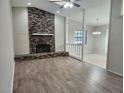 Spacious living room showcasing a brick fireplace, wood floors, and ample natural light at 18232 Monteverde Dr, Spring Hill, FL 34610