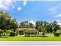 Exterior view of the house, surrounded by lush trees and well-manicured landscaping at 22106 Garmisch Way, Brooksville, FL 34601