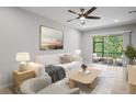 Bright living room with neutral tones, ceiling fan, and access to screened porch with outdoor seating at 3032 Jacob Crossing Ln, Holiday, FL 34691