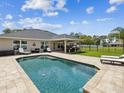 Relaxing pool area with patio seating and covered outdoor living space, perfect for entertaining at 3455 Whispy Ct, Spring Hill, FL 34609