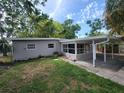 A serene backyard featuring lush greenery, a covered patio, and a well-maintained lawn at 4118 Flamingo Dr, New Port Richey, FL 34652